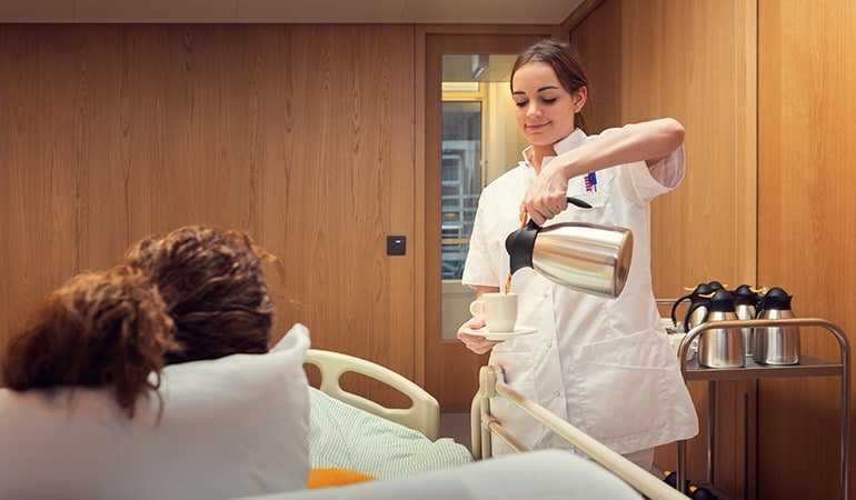 Patientin erhält Kaffee im Krankenhaus